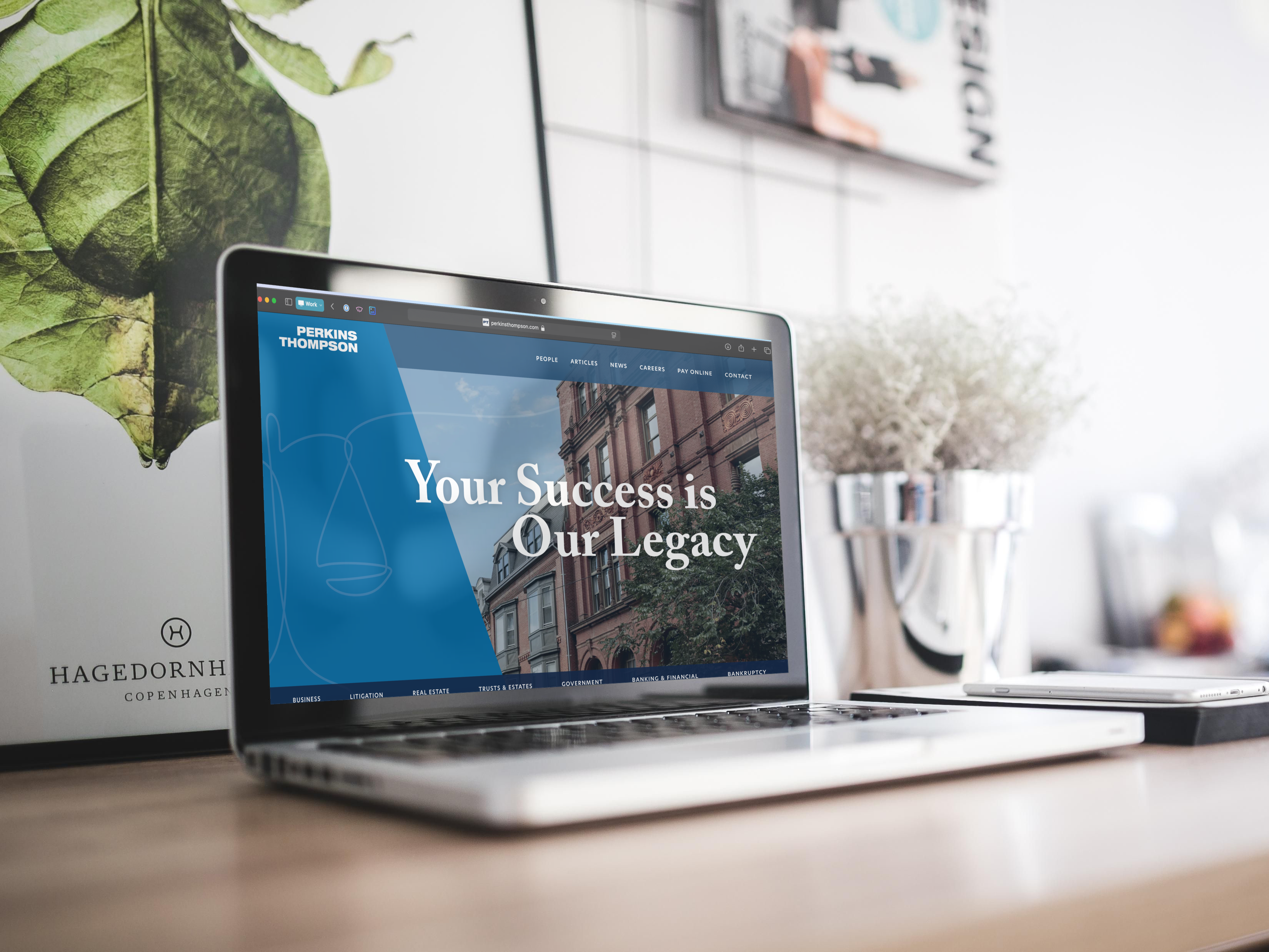 A laptop on a desk displaying the Perkins Thompson website